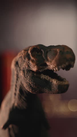 Close-up of a realistic Tyrannosaurus rex toy on a dark background. Detailed plastic dinosaur figurine with dramatic lighting, suitable for themes related to dinosaurs, prehistoric animals, childhood, education, imagination, and collectibles.