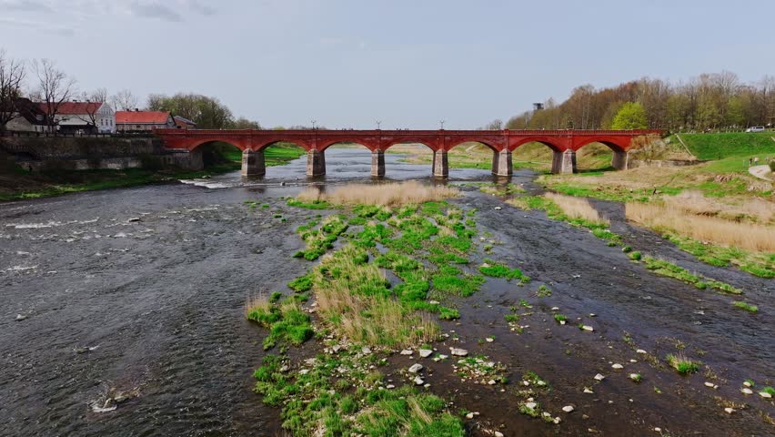 Aerial View of Kuldīga Red Brick Arch Bridge Above Venta in Spring