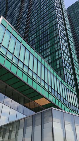 View of the modern glass facade of the Yonge Sheppard Condominium skyscraper reflecting the sky in Toronto, Ontario, Canada.