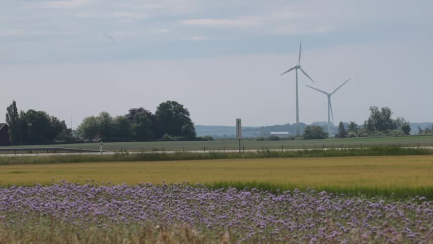 Lund, Sweden A flat farming landscape with a road and wind turbines. 