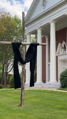 Black cloth draped over the wooden cross in front of a church