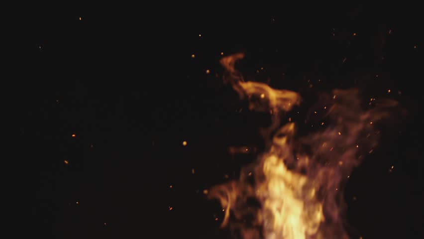 Slow motion fire flames with rising glowing sparks at night.