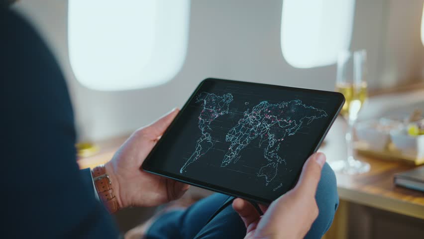 Traveler observing global digital map on tablet in airplane.