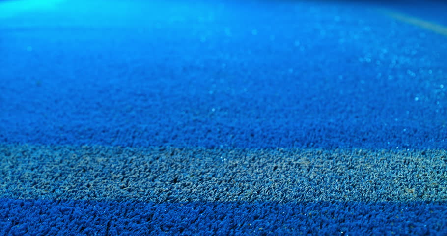 Extreme super slow motion close-up of a tennis or padel ball bouncing near the court line. Detailed blue surface texture captured at 1000fps with dynamic sports action in macro detail.
