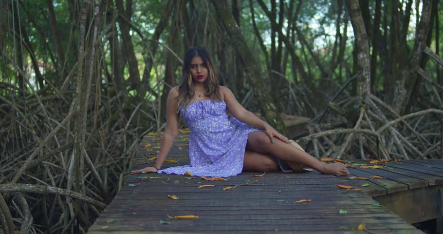Indian girl in a sky-blue dress with tiny blossoms walking a winding trail; fairytale aesthetic in a secret grove.