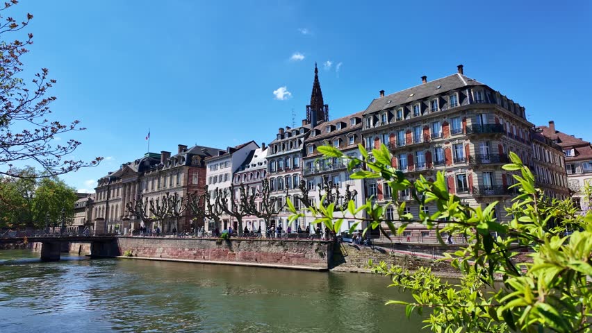 View across the Ill River toward historic Strasbourg buildings and spire.