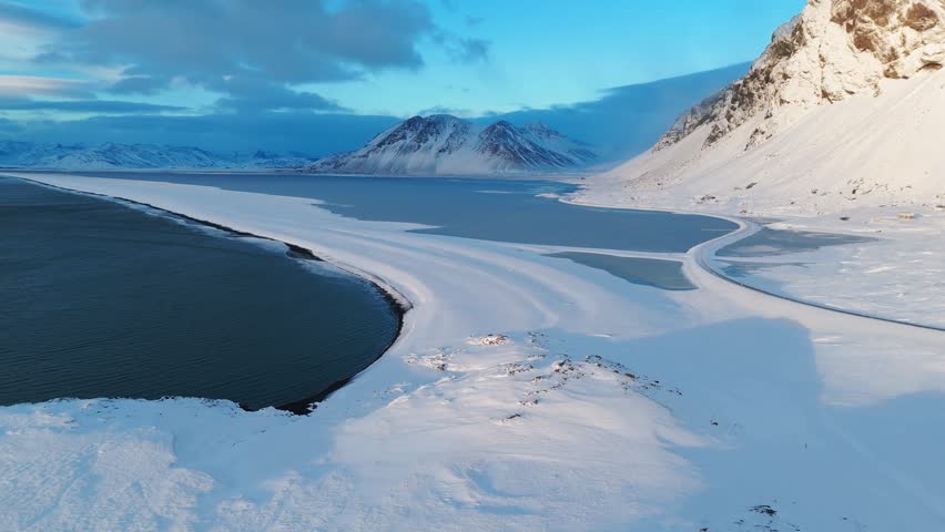 Winter landscape of frozen lagoon and arctic mountains in Iceland