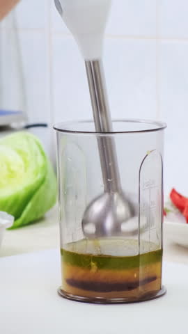 Cook woman in restaurant kitchen make homemade sweet and sour sauce for olive oil salad dressing. Professional chef mix ingredients in blender bowl. Healthy and diet food delivery concept. 4K footage