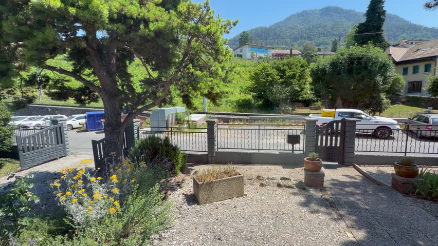 Sunny Garden Entrance with Scenic Mountain Landscape in Switzerland