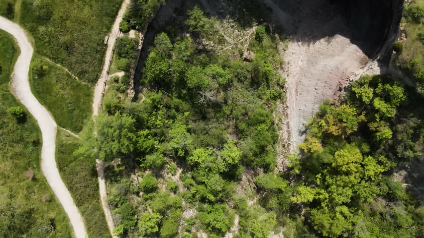 Aerial view of the rocky gorge, lush green forest, and winding hiking trails at the Devil
