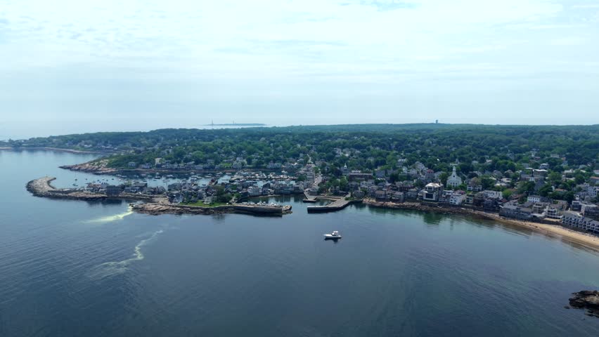 Aerial view of coastal town with harbor, waterfront buildings, and anchored boat
