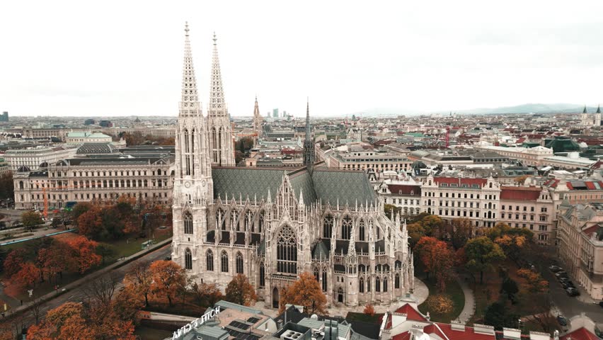 Wide spinning aerial view of the beautiful Votivkirche church in Vienna, Austria.