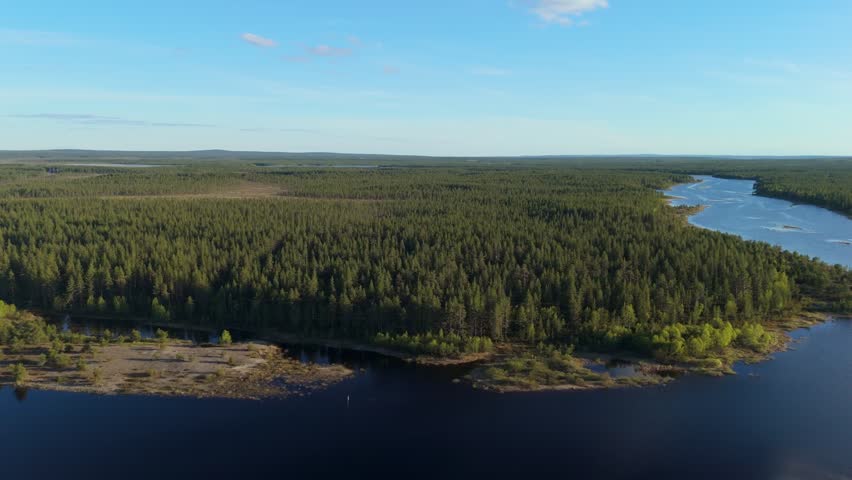 Sodankyla Lake drone reverse move pulling back over dark water and pine forest shoreline in Lapland, northern Finland under clear summer sky.