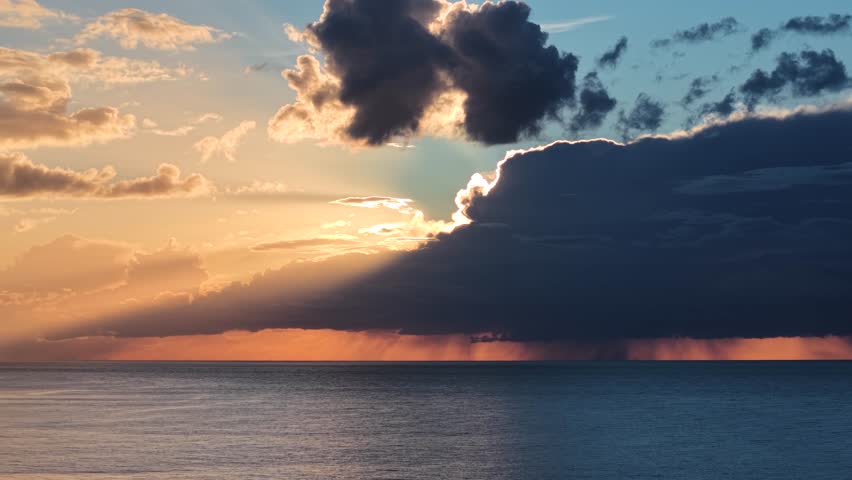 Aerial view of sunset over sea with storm clouds