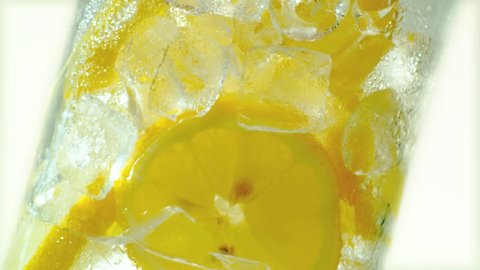 Pouring lemonade into the glass of lemon slices and ice cubes. Stockvideo
