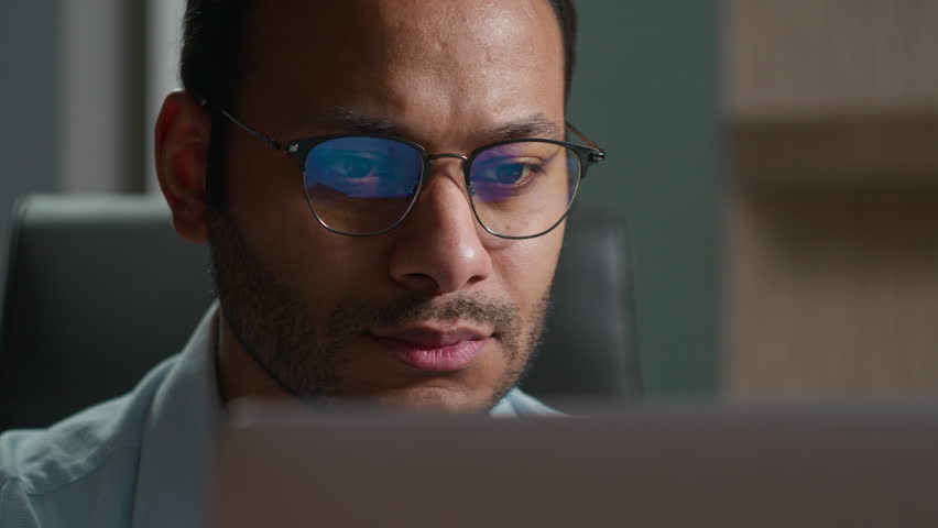Happy joyful Indian business man in glasses paying online credit card laptop indoor glad Arabian office worker shopping internet bank order booking delivery buy app easy fast payment purchase secure