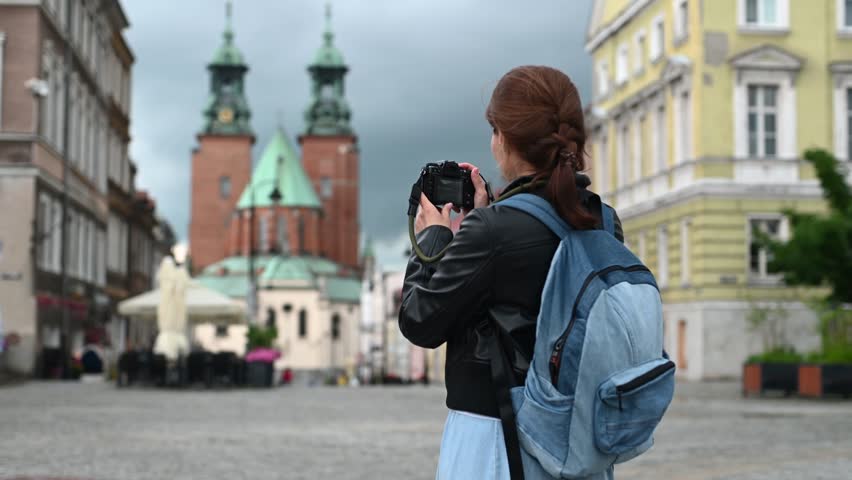 Tourist Woman Photographs Stunning Gniezno Cathedral In Bustling City Center Architecture Scene