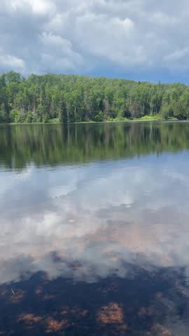 Perfect serenity as clouds close over sunlit lake