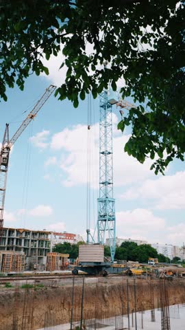 Wide view of an early-stage construction site with excavated foundations prepared for a future residential building.