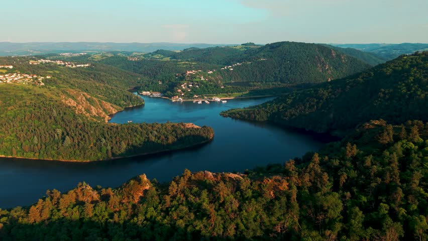 Aerial shot at sunset over the loire river and the Gorges de la Loire near Saint Etienne with SAunt Victor sur Loire village in the background , Loire departement, Auvergne Rhone Alpes region, France