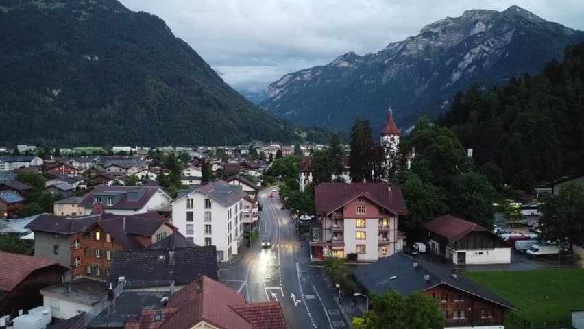 A Stunning Drone view of Interlaken Town and Swiss Alps in the Distance in a cloudy evening in Switzerland