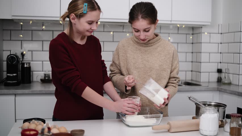 Sisters Bake Gingerbread Cookies For Christmas, Pouring Flour Into The Dough Mixture