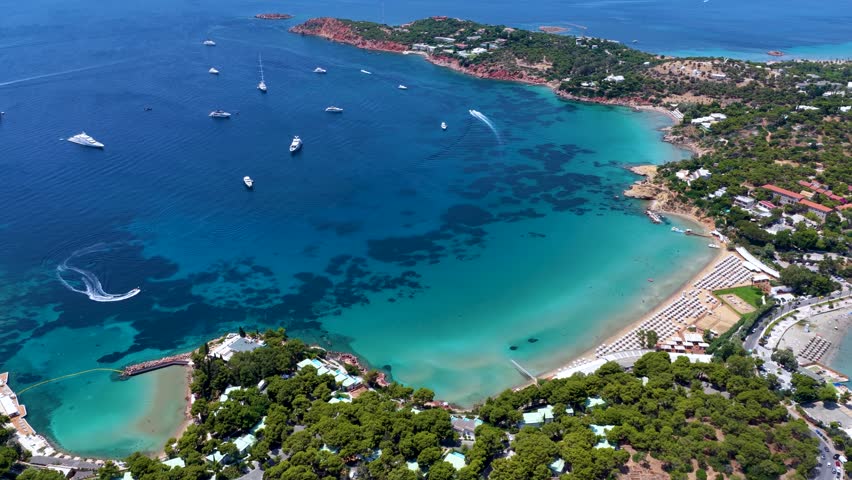 Aerial view of the popular Astir Beach in Vouliagmeni, south Athens coast, Greece, with turquoise sea and moored luxury yachts during summer time