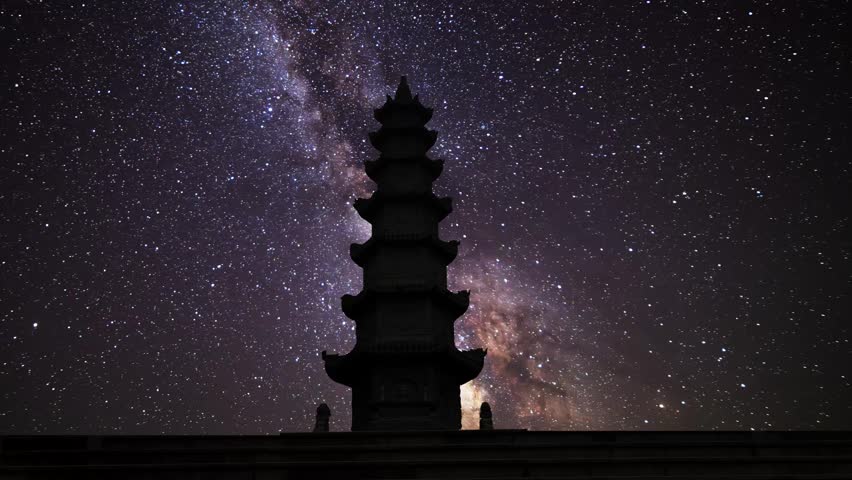 Buddhist temple on the bright milky way background. Night starry sky.