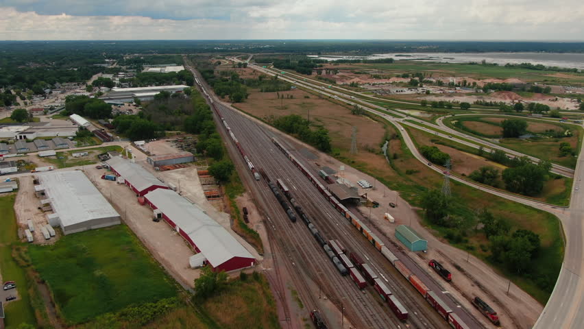 Train cars in Green Bay rail yard, Wisconsin, USA. Aerial backwards across highway bridge