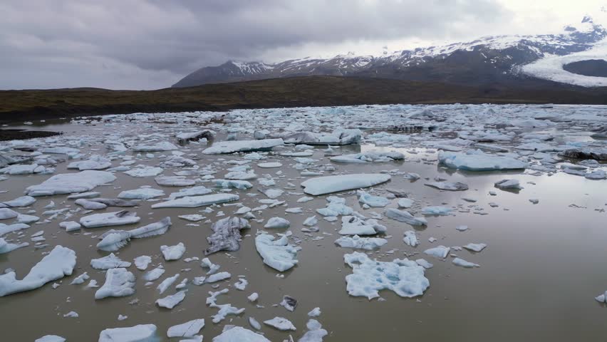 a lake with murky waters covered with pieces of the glacier that lies at the bottom