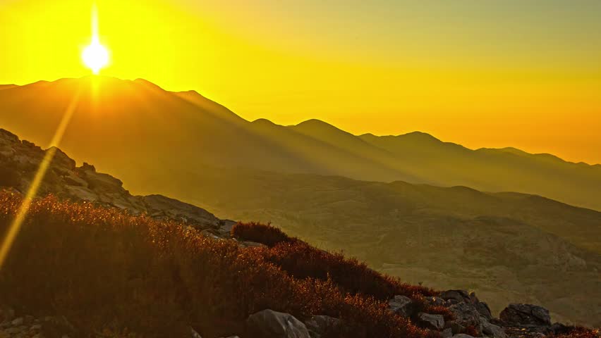 Golden sunset beyond mountain ridge timelapse