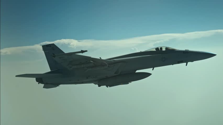 U.S. Navy F-18E Super Hornet fighter jet releasing defensive flares during a military flight operation. Advanced carrier-based multirole combat aircraft demonstrating electronic countermeasures, tactical maneuvering, and modern naval aviation capability.