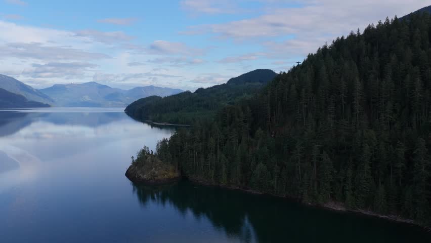 Majestic Harrison Lake in British Columbia, Canada with Forested Mountains and Calm Water Reflection