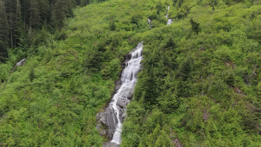 Majestic Waterfall Cascading Through Lush Green Forest in British Columbia, Canada