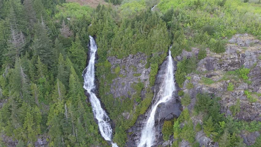 Majestic Twin Waterfalls Cascade Down a Lush Forested Mountainside in British Columbia, Canada