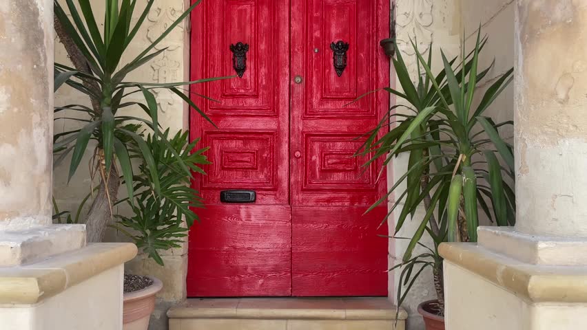 Red doorway with black knobs in Malta