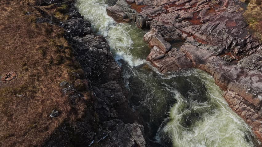 Aerial view of the river etive carving its way through a rugged rock gorge in glencoe, scotland. Wild water foaming over rocks