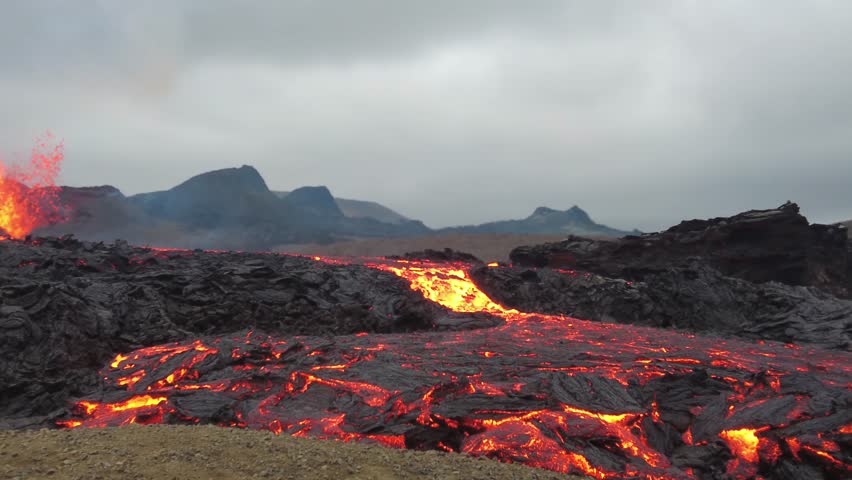 wide View of Active Lava Rivers Flowing Through Iceland Volcanic Landscape with Distant Erupting Vent