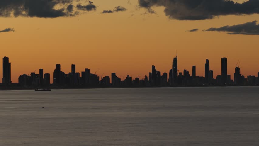 Silhouette Skyline Of Surfers Paradise Viewed From The Ocean During Sunset In Queensland, Australia. - aerial shot