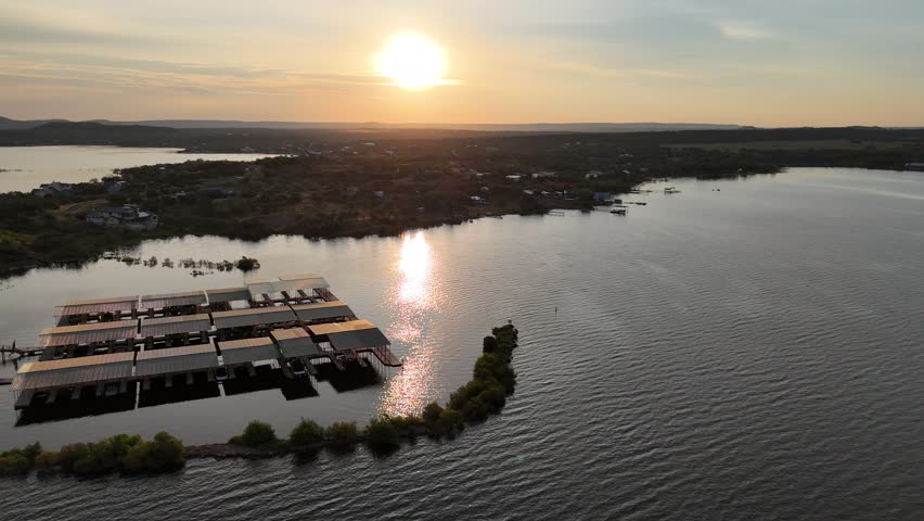 Aerial view of hazy sunrise over the lake with marinas and mansions