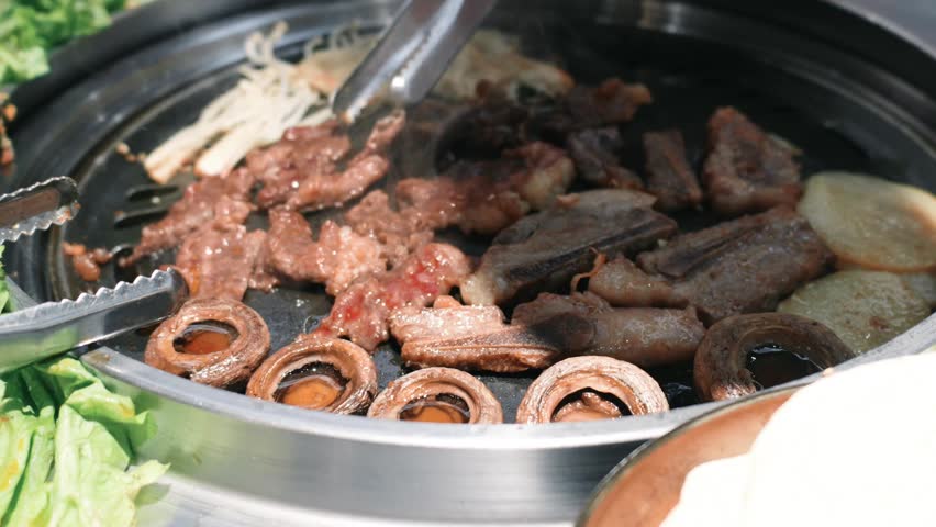 Korean BBQ Grill with Sizzling Beef Ribs, Mushrooms, and Lettuce Wraps in Seoul