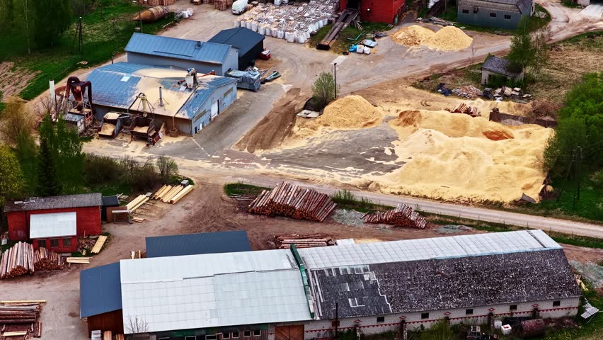 Industrial sawmill facility with buildings, wood processing equipment, and large piles of lumber