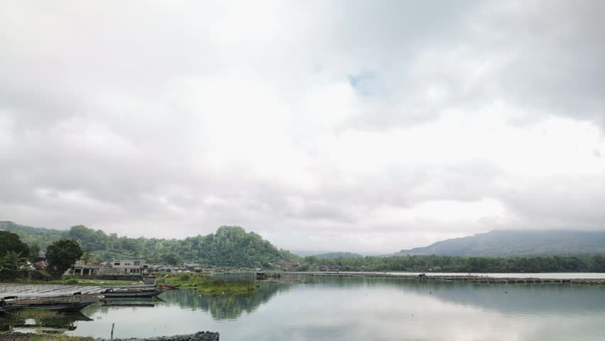 Calm lake with water reflection of mountain and cloudy sky