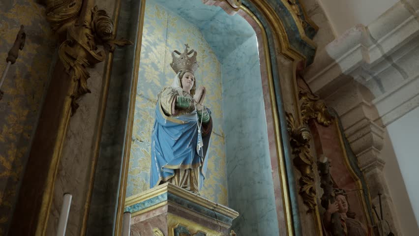 An old, detailed religious statue of a saint or Virgin Mary in a beautifully decorated church niche, perfect for historical or spiritual projects.