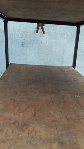 Hand showing a reverse peace sign or victory gesture underneath a table