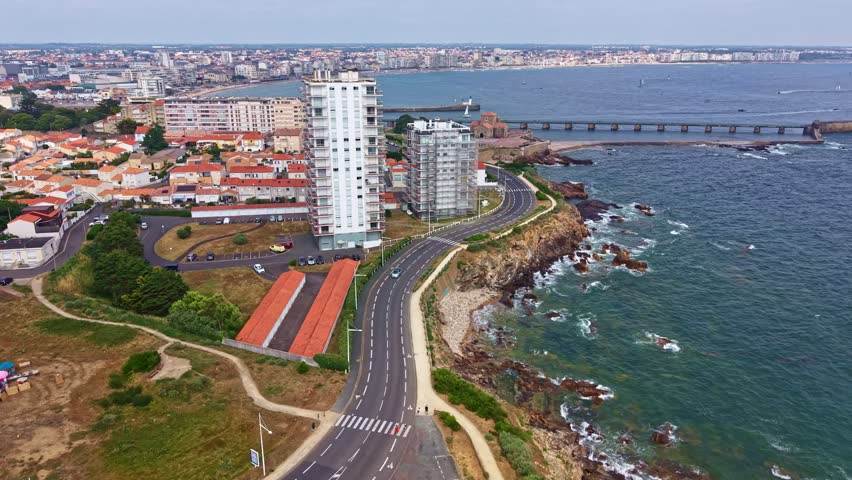 Modern apartment buildings and coastal road with Petite et Grande jétée in background, Les Sables-d