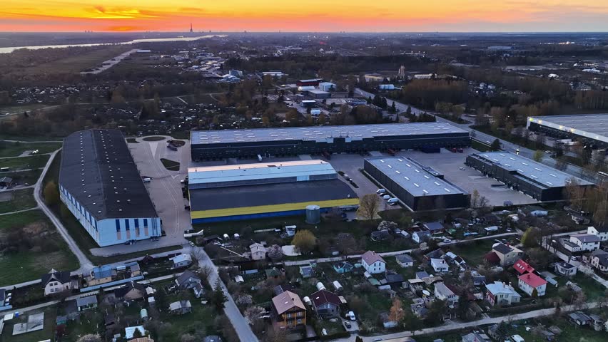 Industrial warehouses and logistics center in Riga, Latvia, during a colorful sunset