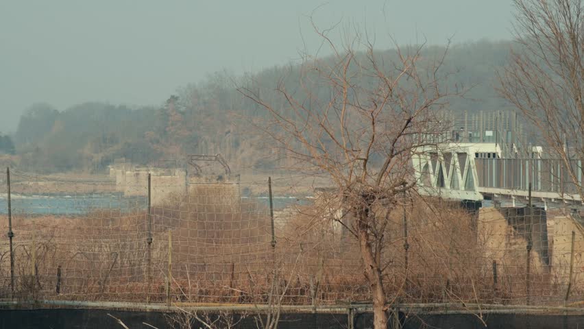 Military Barbed Wire Fence and the Dokdo Bridge Pier Ruins Near the Demilitarized Zone in Paju, South Korea
