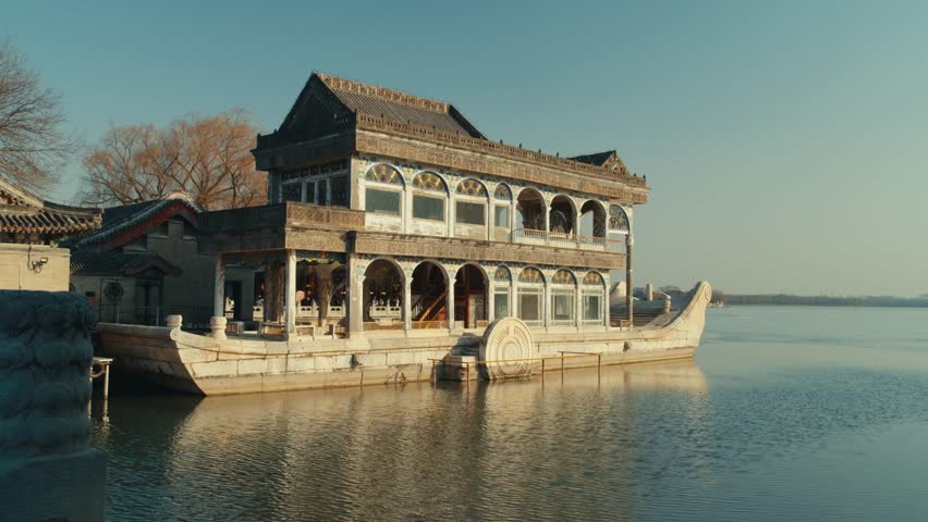 Beijing Side profile of the Marble Boat at the Summer Palace, featuring intricate stone masonry set against the reflective, partially frozen surface of Kunming Lake