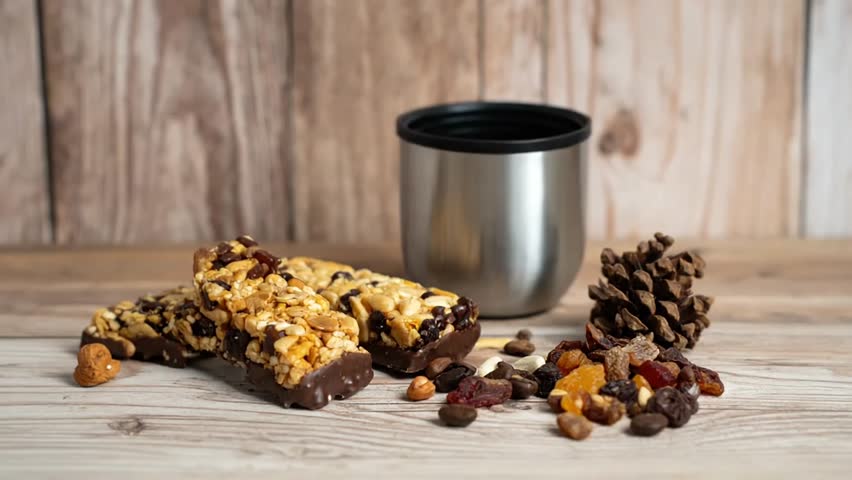 Delicious granola bars with nuts and raisins on a wooden table
